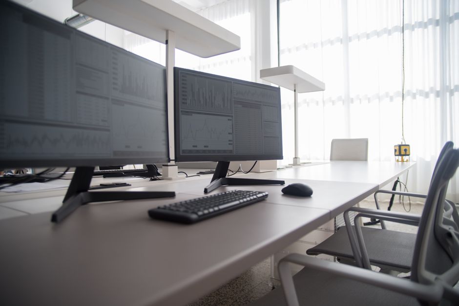 Stylish contemporary office featuring multiple computer monitors and ergonomic chairs.